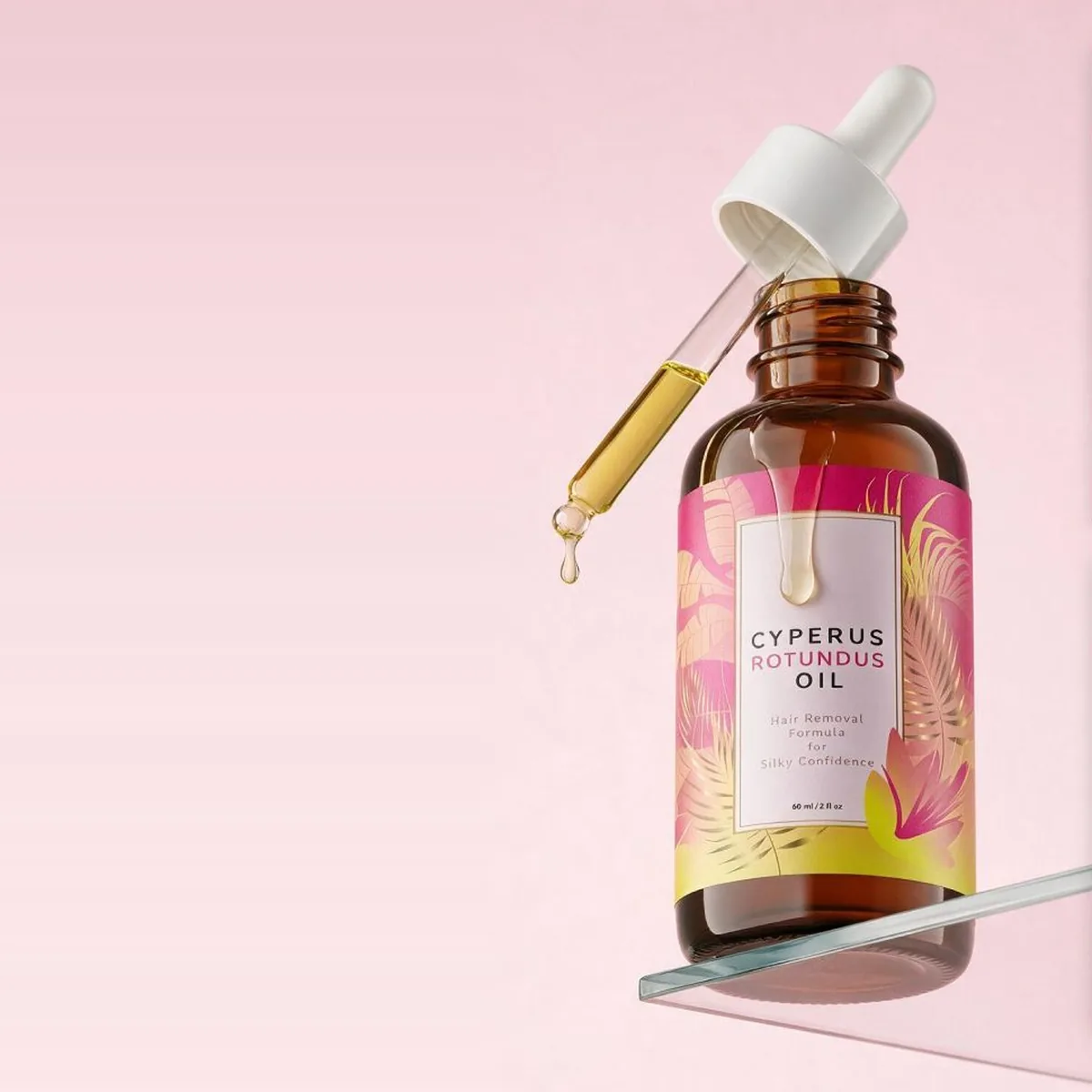 An open Oilume bottle on a glass shelf, its dropper full of golden oil with a drop about to fall